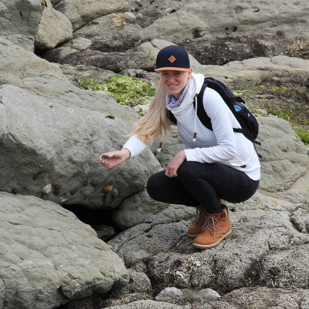 Instagram photo of Claudia with a shell on the rocks at Kaikoura